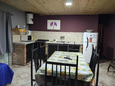 a kitchen with a table and a white refrigerator at Departamentos sandry in Villa Carlos Paz