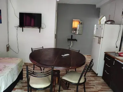 a kitchen with a table and chairs and a refrigerator at Departamentos sandry in Villa Carlos Paz