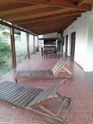 a screened porch with a table and chairs on it at La Morada de tus Sueños VCP con vista al LAGO in Villa Carlos Paz