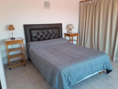 a bedroom with a bed and two night stands with lamps at La Morada de tus Sueños VCP con vista al LAGO in Villa Carlos Paz