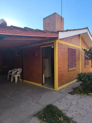 a small brick house with a refrigerator and a table at Sweet Angel in Villa Cura Brochero