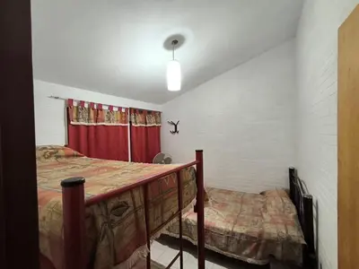 a bedroom with a bed and a red curtain at Sweet Angel in Villa Cura Brochero