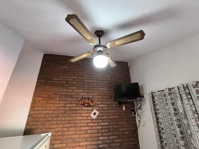 a ceiling fan in a room with a brick wall at Sweet Angel in Villa Cura Brochero