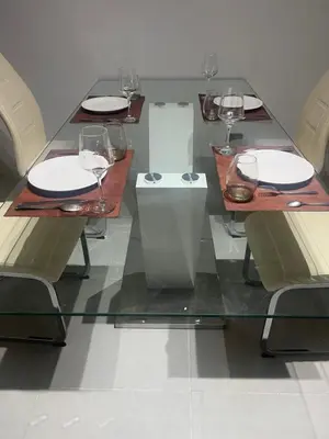 a glass table with plates and wine glasses on it at Departamento en Nueva Córdoba, Córdoba Capital in Cordoba