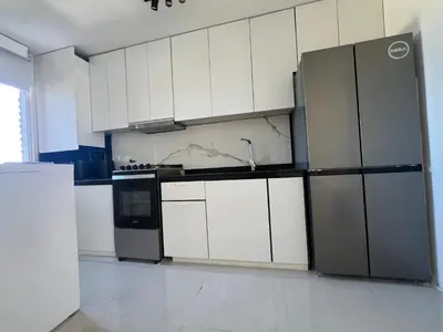 a kitchen with white cabinets and a stainless steel refrigerator at Departamento en Nueva Córdoba, Córdoba Capital in Cordoba