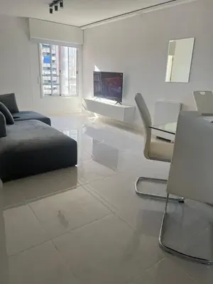 a white living room with a bed and a tv at Departamento en Nueva Córdoba, Córdoba Capital in Cordoba