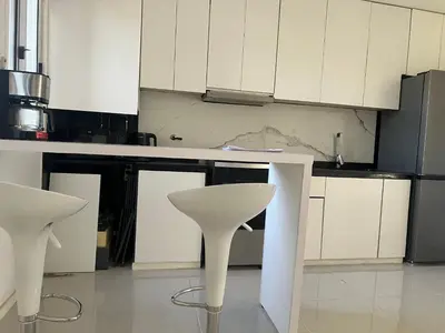 a kitchen with white cabinets and a white chair at Departamento en Nueva Córdoba, Córdoba Capital in Cordoba