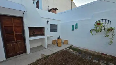 a white house with a door and a fireplace at Temporario HOSPITAL PRIVADO, QUALITY, con cochera en CORDOBA in Cordoba