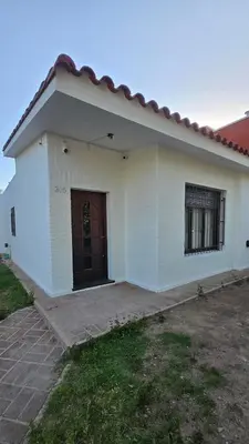a white house with a door in a yard at Temporario HOSPITAL PRIVADO, QUALITY, con cochera en CORDOBA in Cordoba