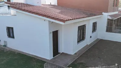 a white house with a red tile roof at Temporario HOSPITAL PRIVADO, QUALITY, con cochera en CORDOBA in Cordoba
