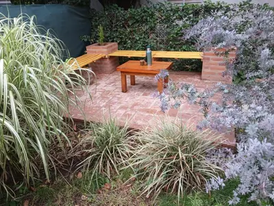 a wooden bench in a garden with plants at Cabañas Mairu in Potrero de Garay
