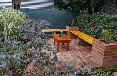 a wooden bench and a table in a garden at Cabañas Mairu in Potrero de Garay