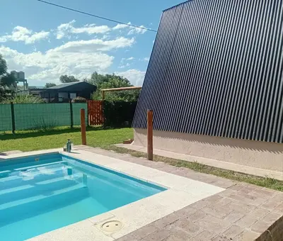 a swimming pool in a yard next to a fence at Cabañas Mairu in Potrero de Garay