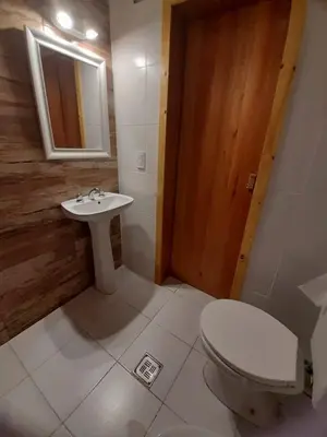 a bathroom with a white toilet and a sink at Cabañas Mairu in Potrero de Garay