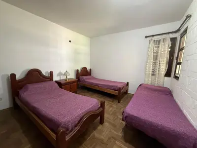 two beds in a room with purple sheets at Casa TOKIO in Villa Carlos Paz