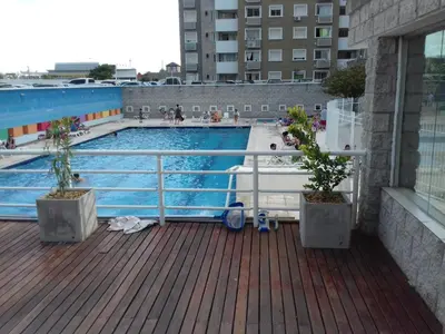 a swimming pool with two potted plants on a deck at Temporario en Villa Sol in Cordoba