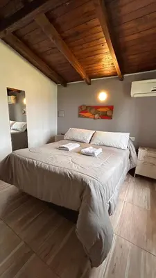 a bedroom with a large bed with two towels on it at Capri Hotel y Cabañas in Villa Carlos Paz