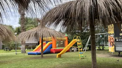 a playground with a slide and a slideintend at Capri Hotel y Cabañas in Villa Carlos Paz