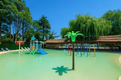 a playground in a park with a pool of water at Capri Hotel y Cabañas in Villa Carlos Paz