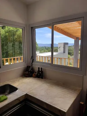 a kitchen with two windows and a counter with a sink at Mi Destino in Tanti Nuevo