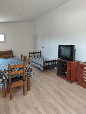 a living room with a tv and tables and chairs at Mi Destino in Tanti Nuevo