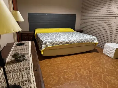 a bedroom with a bed and a brick wall at Casa privada con piscina y quincho Altavip in Villa Cura Brochero
