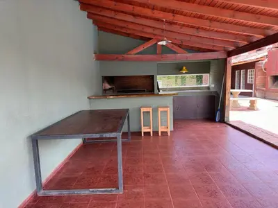 a table in the middle of a room with a kitchen at Casa privada con piscina y quincho Altavip in Villa Cura Brochero