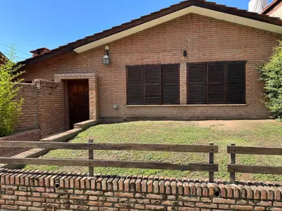 a brick house with a fence in front of it at Casa privada con piscina y quincho Altavip in Villa Cura Brochero