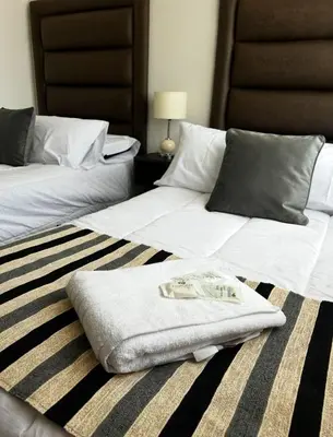 two beds with towels on the floor in a bedroom at Departamento Premiun con Cochera en Villa Dolores in Villa Dolores