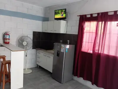 a kitchen with a refrigerator and a tv on the wall at Monoambiente cosquin in Cosquín