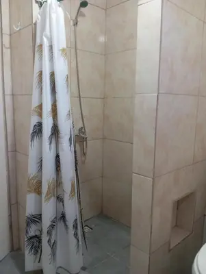 a shower with a shower curtain with palm trees at Monoambiente cosquin in Cosquín