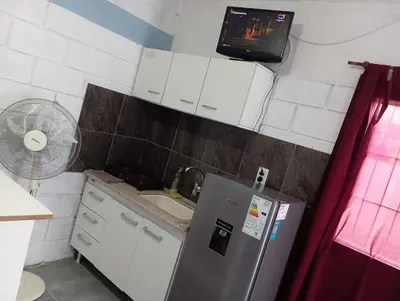 a small kitchen with a refrigerator and a fan at Monoambiente cosquin in Cosquín