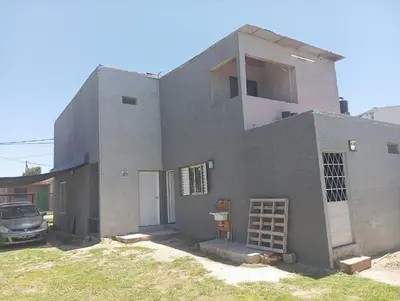 a gray house with a car parked in front of it at Monoambiente cosquin in Cosquín