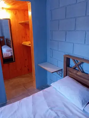 a blue room with a bed and a shelf at Monoambiente cosquin in Cosquín