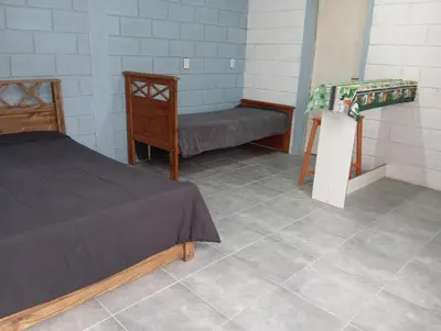 a room with a bed and a bench and a table at Monoambiente cosquin in Cosquín