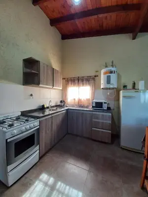 a kitchen with a stove and a refrigerator at La Tranquila in Villa Yacanto