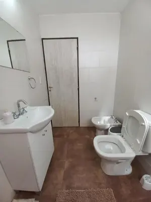 a white bathroom with a toilet and a sink at La Tranquila in Villa Yacanto