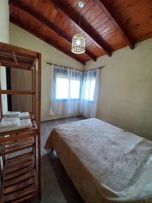 a bedroom with a large bed and a window at La Tranquila in Villa Yacanto