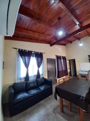 a living room with a black couch and a table at La Tranquila in Villa Yacanto