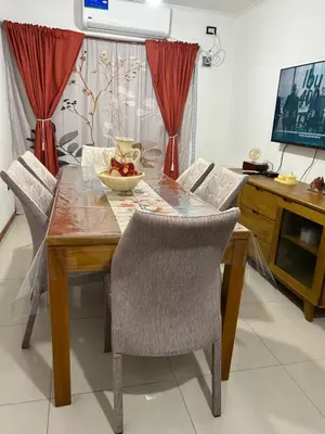 a dining room table with chairs and a bowl of fruit on it at Dpto Carlos Paz in Villa Carlos Paz