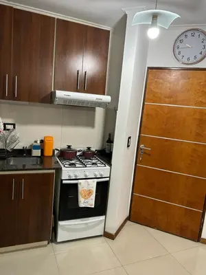 a kitchen with a stove and a clock on the wall at Dpto Carlos Paz in Villa Carlos Paz