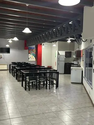 a cafeteria with tables and chairs and a kitchen at Dpto Carlos Paz in Villa Carlos Paz