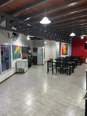 a large room with tables and chairs and a kitchen at Dpto Carlos Paz in Villa Carlos Paz