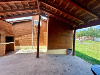 an outdoor patio with a brick wall and awning at Shanti Cabañas in Mina Clavero