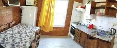 a small kitchen with a sink and a refrigerator at Shanti Cabañas in Mina Clavero