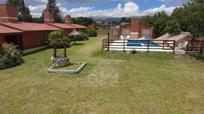 a yard with a house and a swimming pool at Shanti Cabañas in Mina Clavero