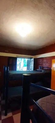 a living room with a television and a table and chairs at Habitación Compartida Tipo Hostel para los más aventureros in Nono