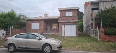 a silver car parked in front of a brick house at El sueño de papá in Santa María