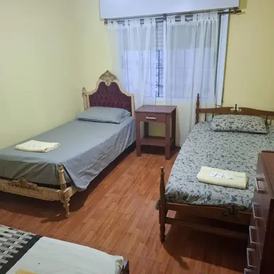 a bedroom with two beds and a table and a window at El sueño de papá in Santa María