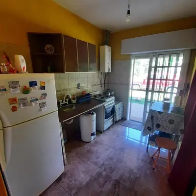 a kitchen with a white refrigerator and a table at El sueño de papá in Santa María